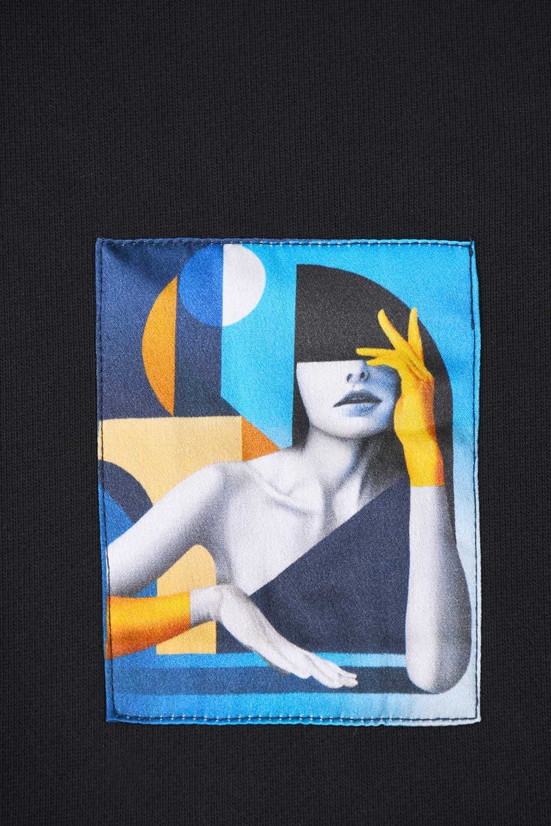 Détail oeuvre Hoodie noir avec oeuvre "Riviera" en miniature sur le coeur du vêtement. Collection capsule avec l'artiste français SKIO