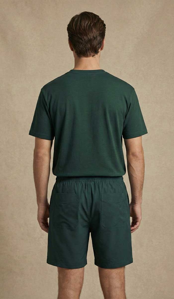 MANNEQUIN HOMME EST VETU DU TEE SHIRT VERT ET SHORT ASSORTI POSE DEBOUT DOS A L'OBJECTIF 