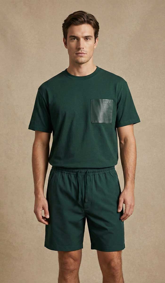 MANNEQUIN HOMME EST VETU DU TEE SHIRT VERT ROYAL ET SHORT ASSORTI POSE DEBOUT FACE A L'OBJECTIF 