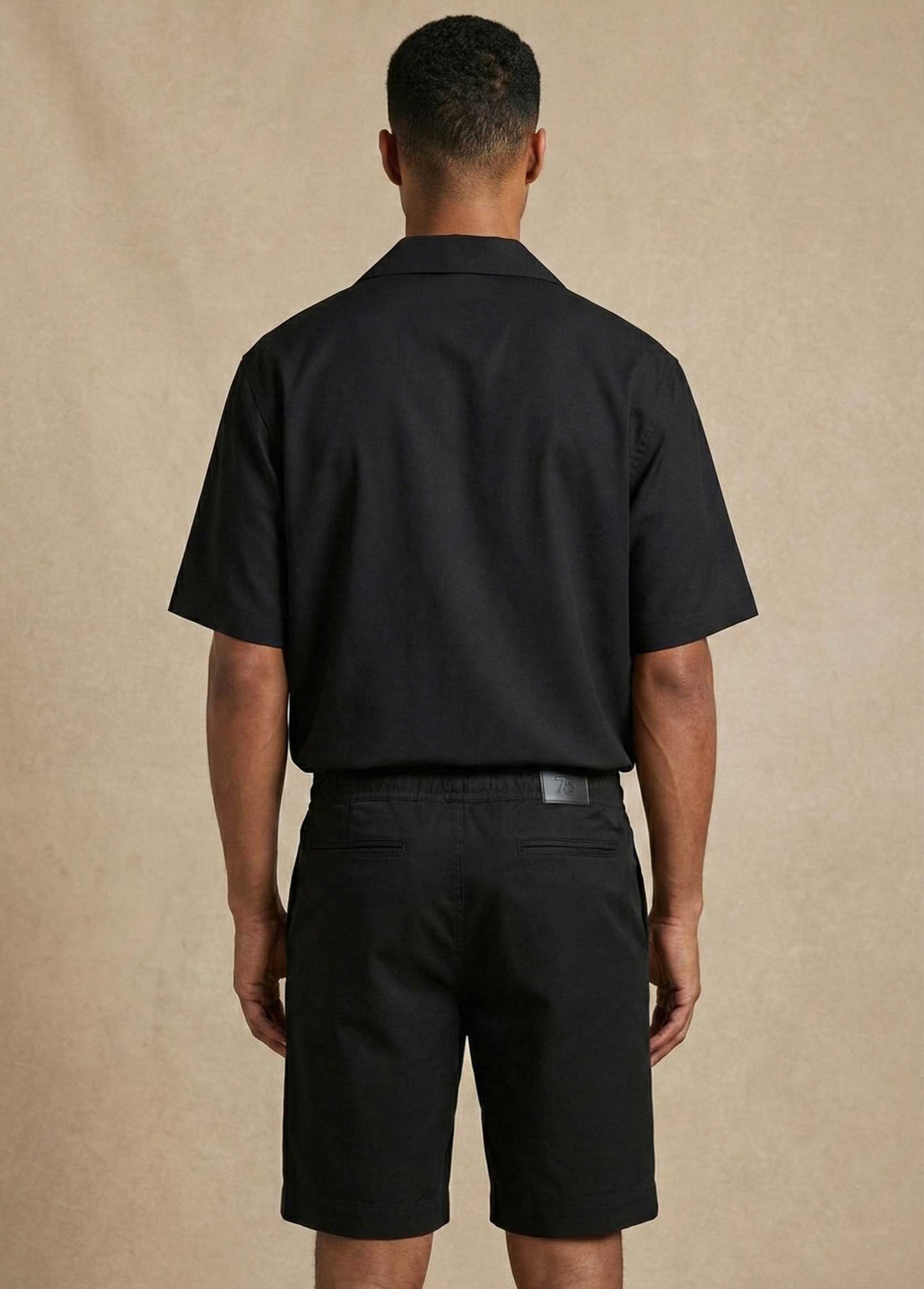 homme debout chemise noire G75 de dos