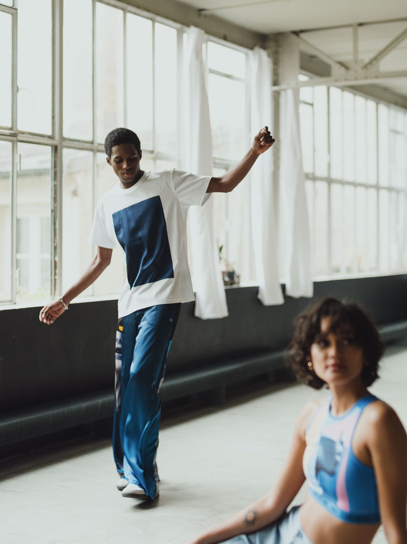 Modele Homme portant Pantalon bleu 100% soie avec oeuvre "Riviera" de l'artiste français SKIO