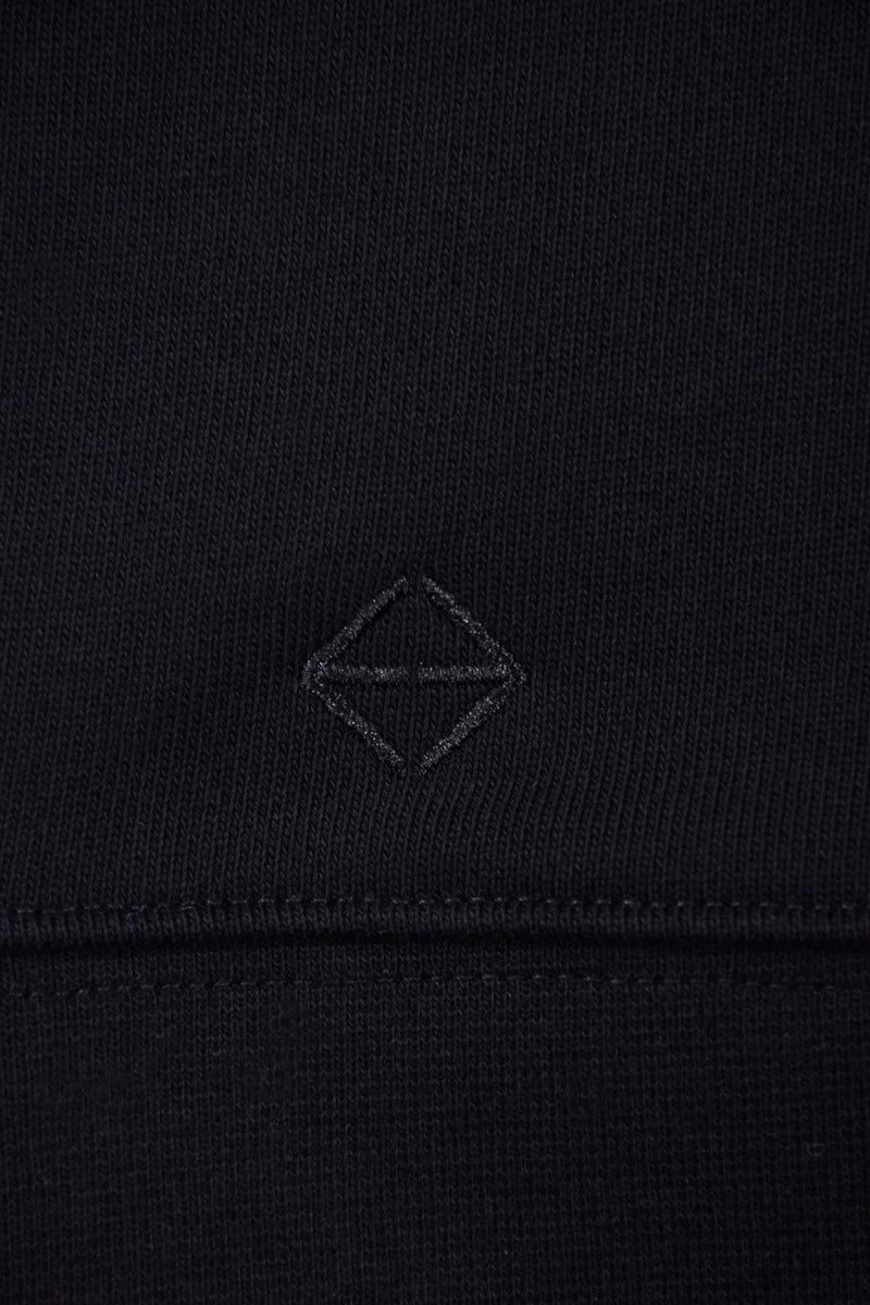 le logo broderie ton sur ton noir en bas du hoodie